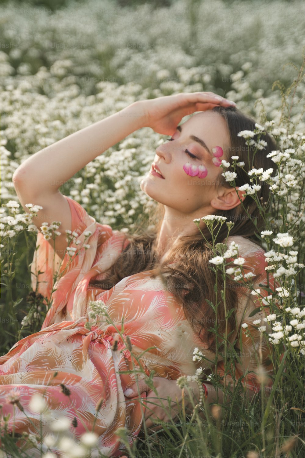 uma mulher deitada em um campo de flores brancas