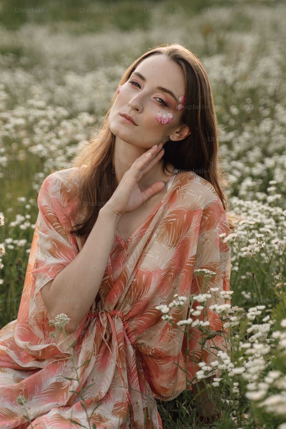 Eine Frau, die in einem Feld mit weißen Blumen sitzt
