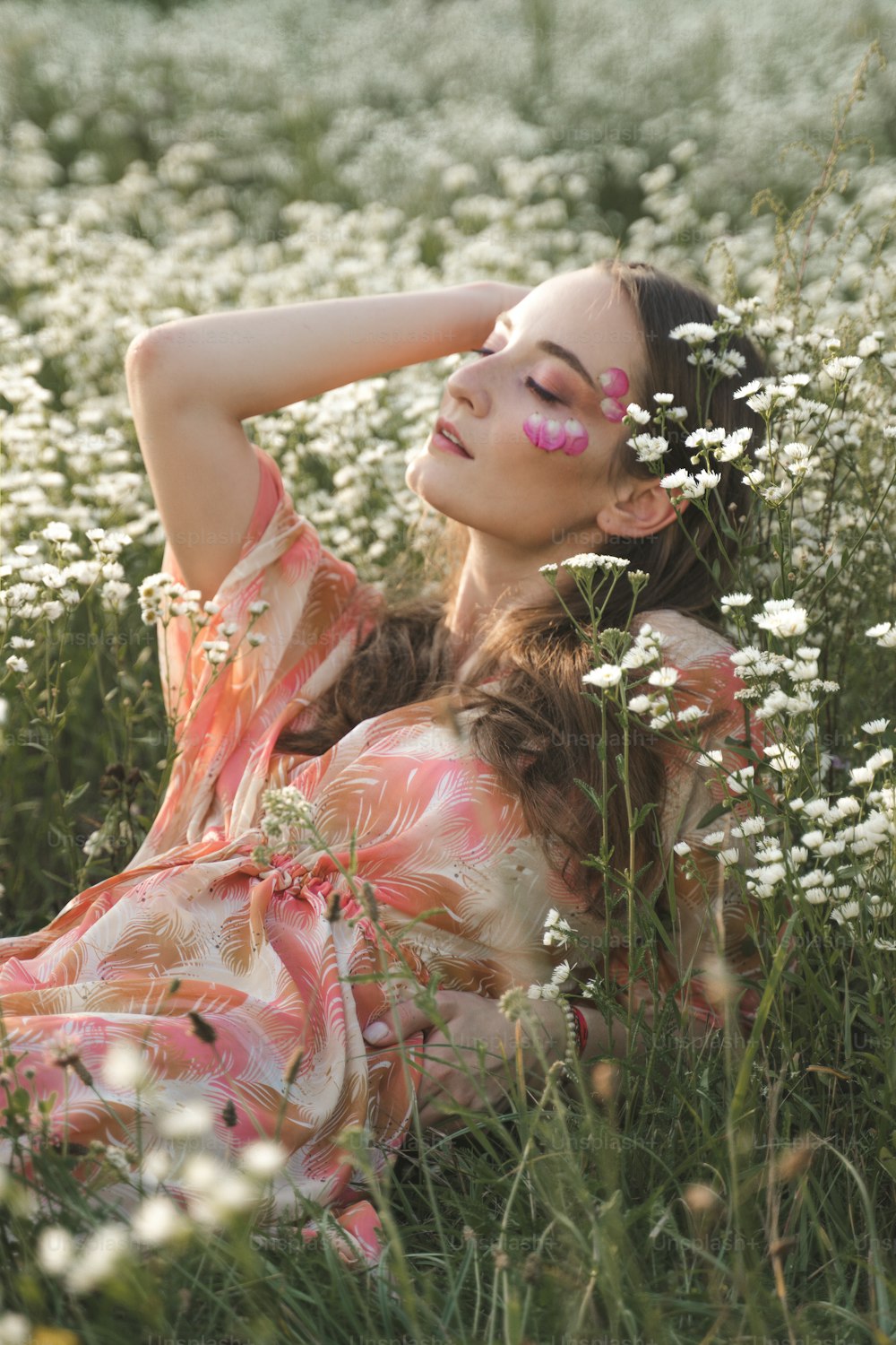 Una mujer acostada en un campo de flores blancas