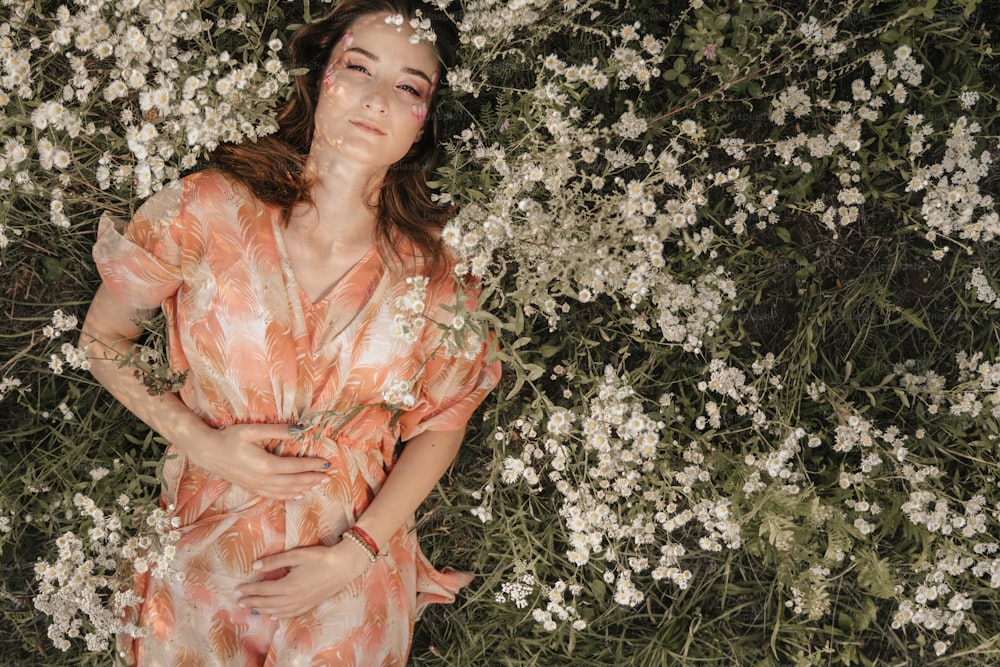 a woman laying in a field of flowers