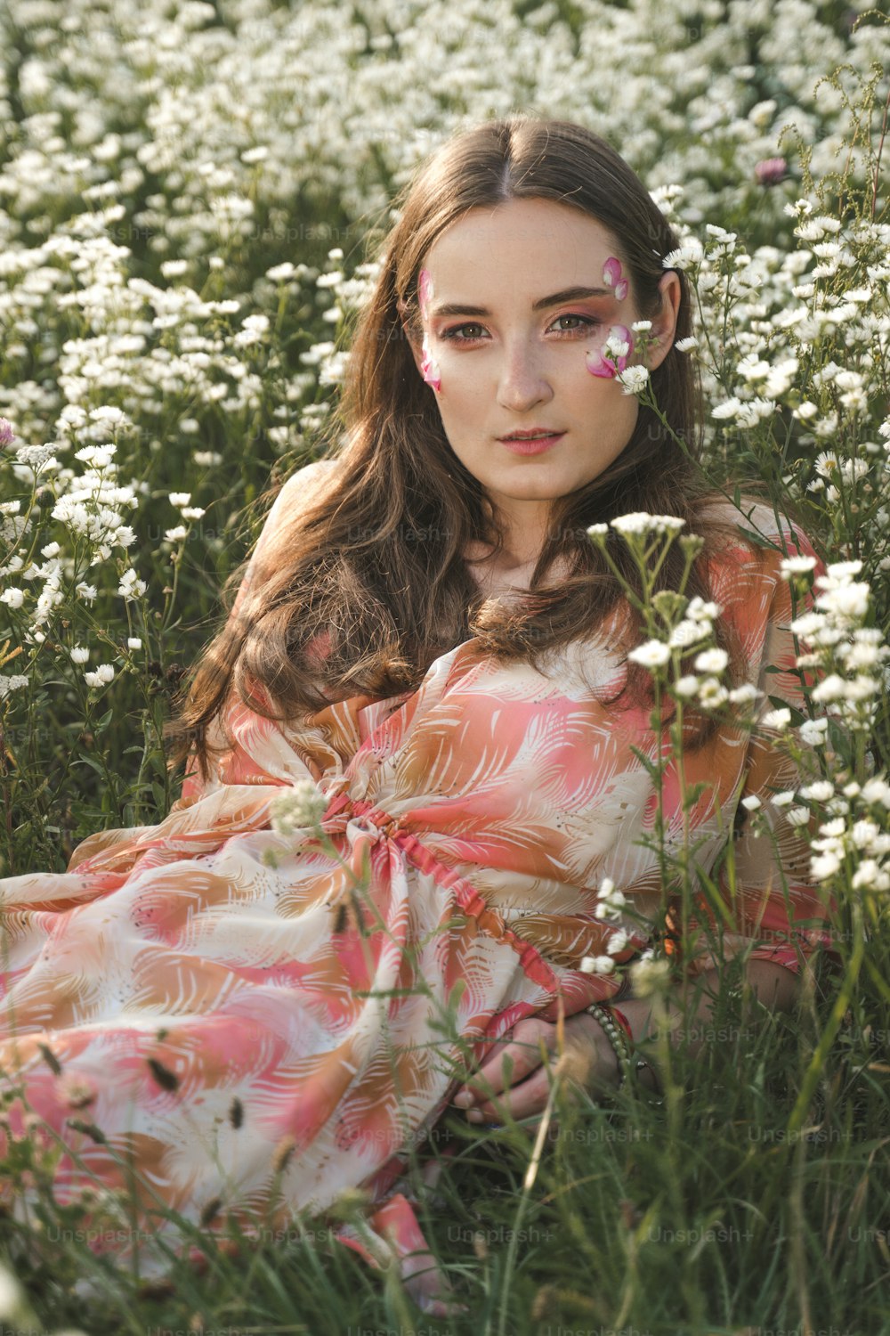 a woman sitting in a field of white flowers