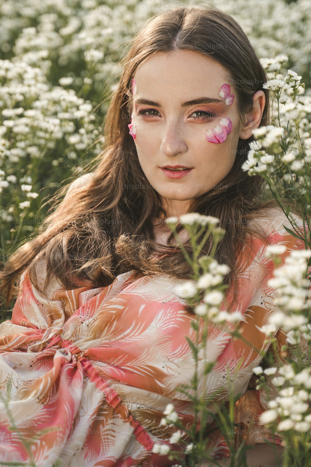 Eine Frau mit einem bemalten Gesicht in einem Blumenfeld
