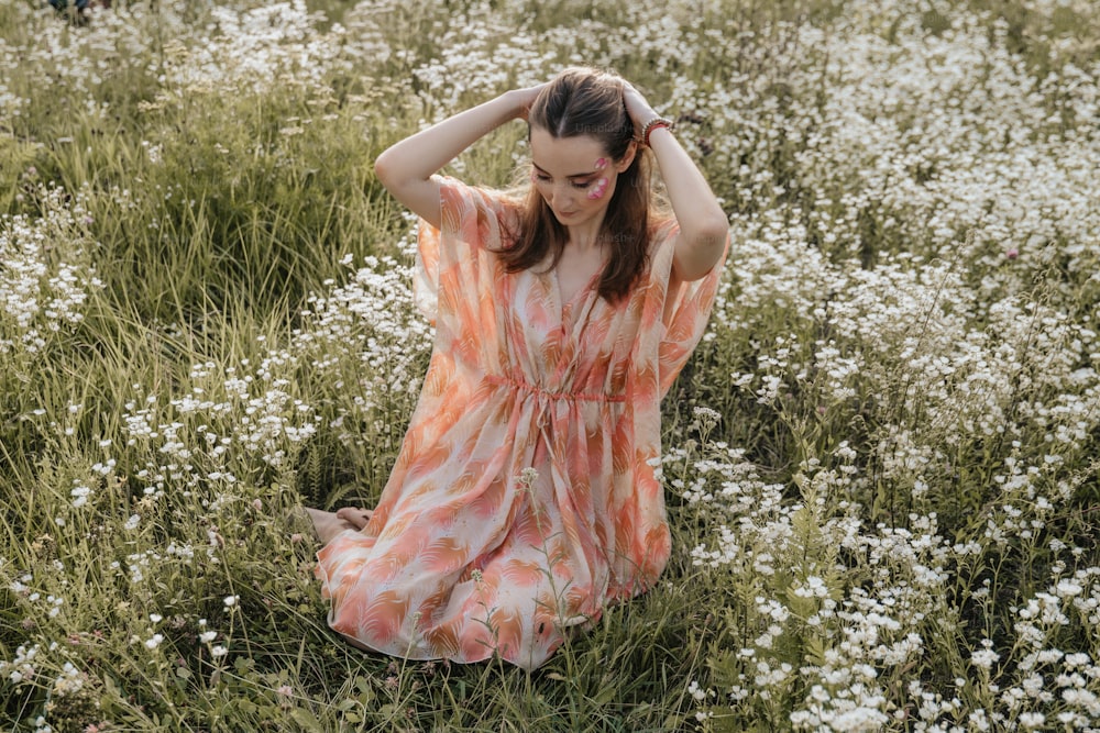 a woman is sitting in a field of flowers
