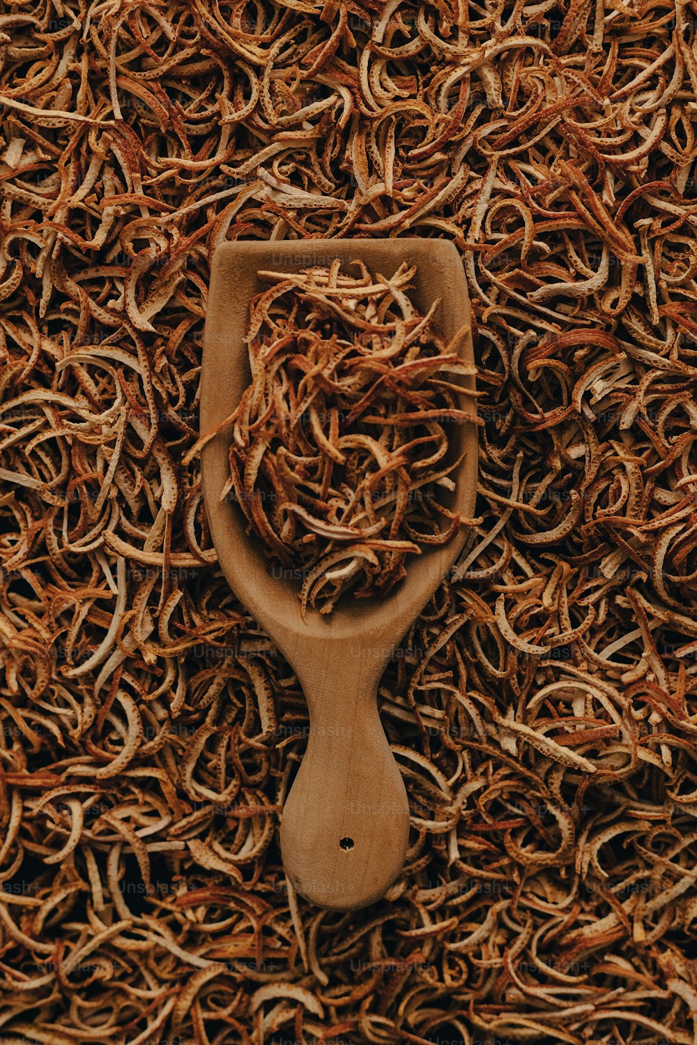 a wooden spoon sitting on top of a pile of dried grass