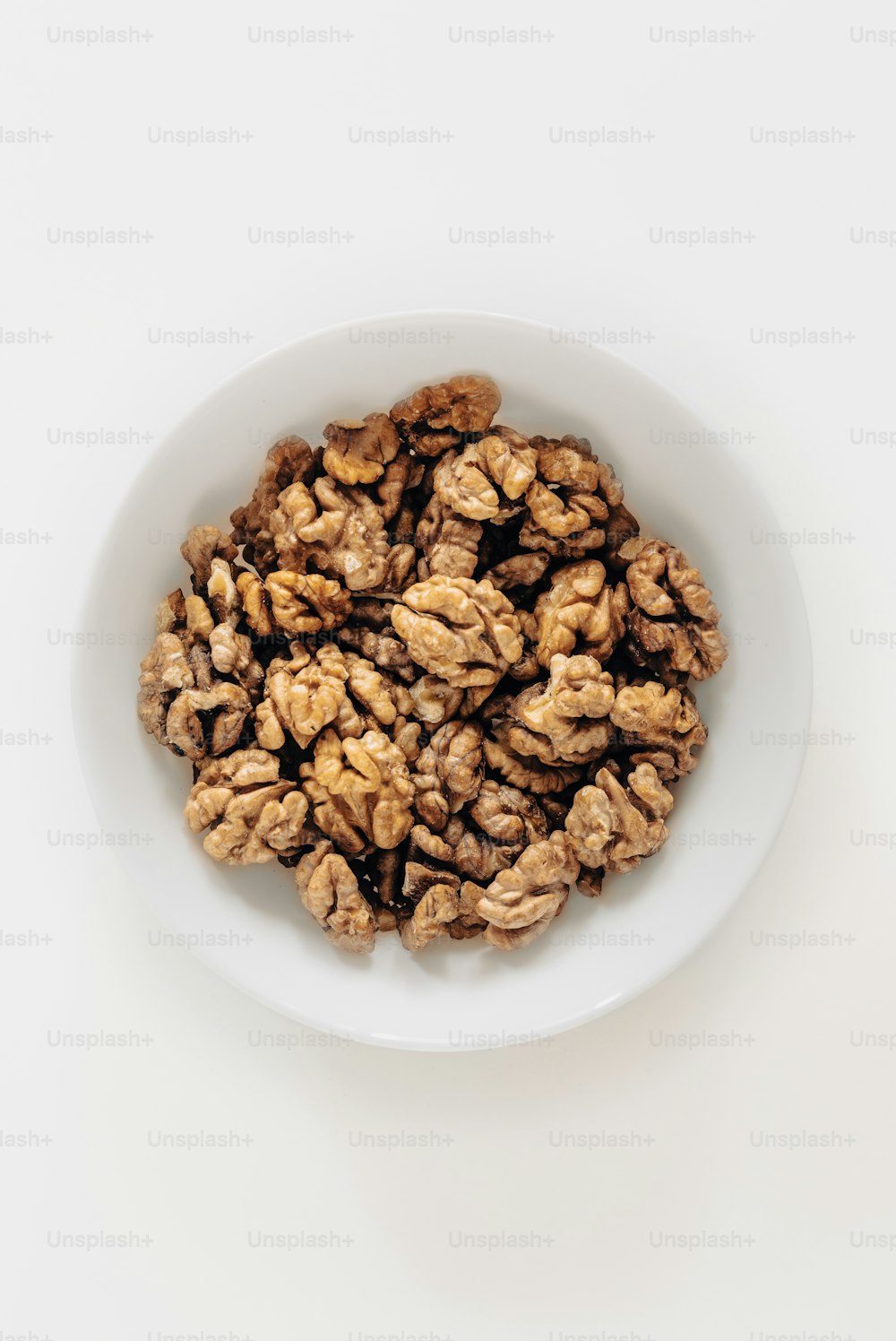 a white bowl filled with walnuts on top of a table