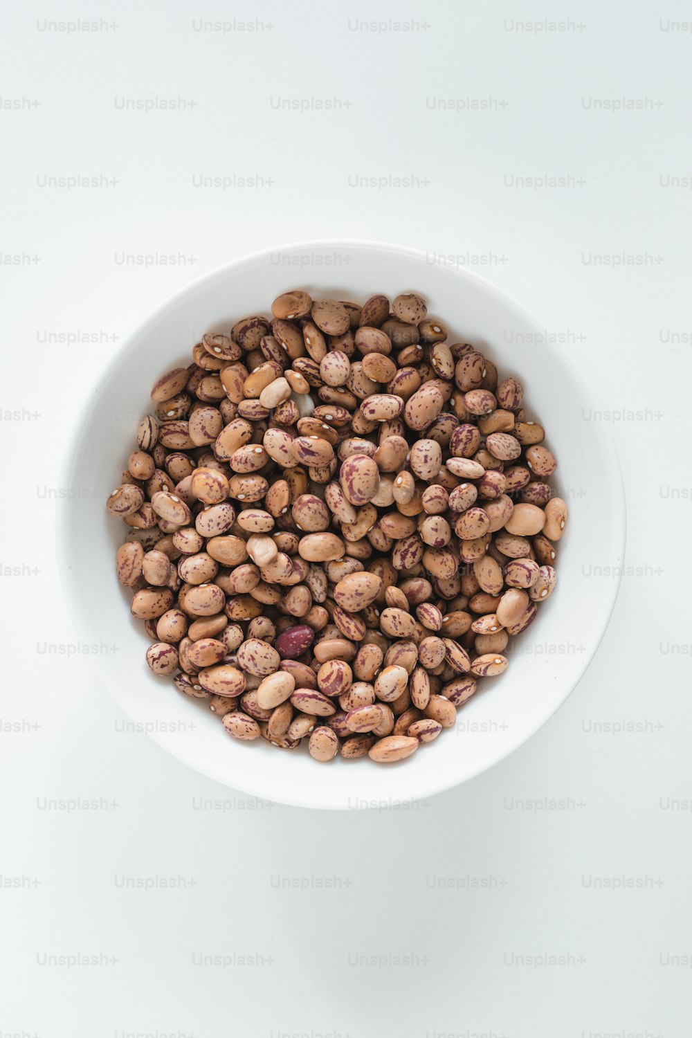 a white bowl filled with nuts on top of a table