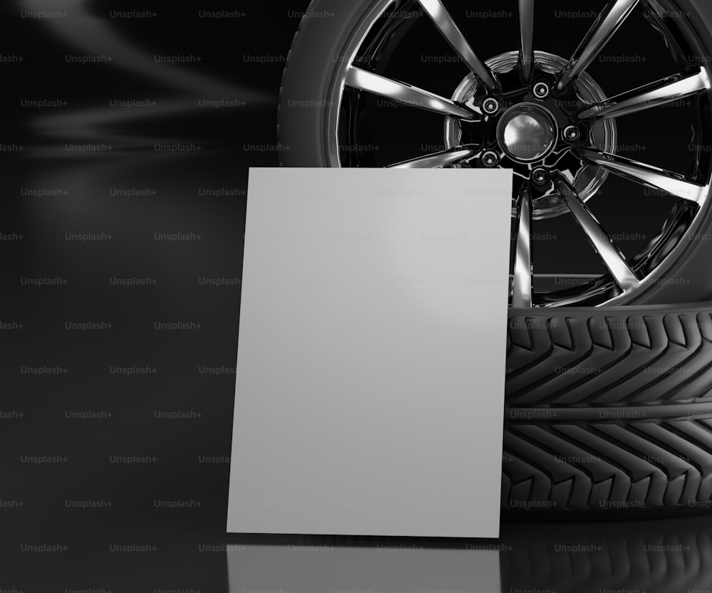 un neumático de coche con una tarjeta en blanco al lado