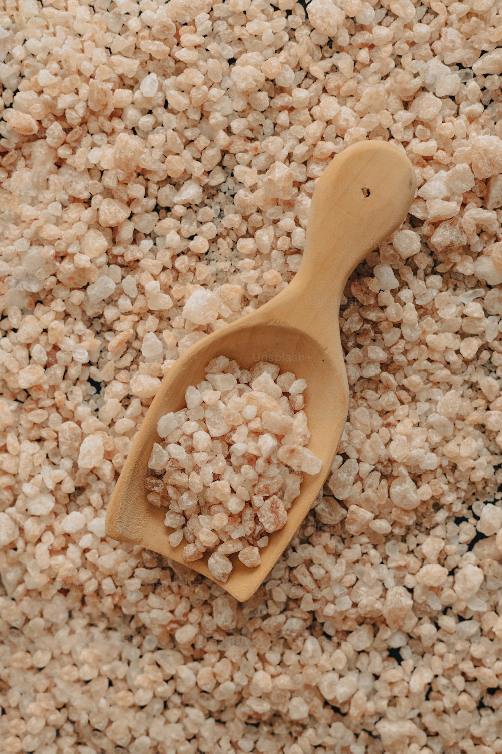 a wooden spoon filled with oatmeal on top of a pile of o