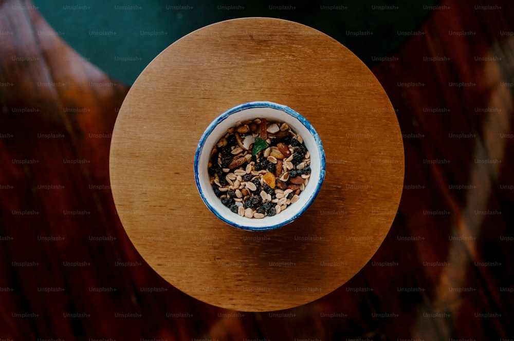 a blue and white bowl filled with food on top of a wooden table