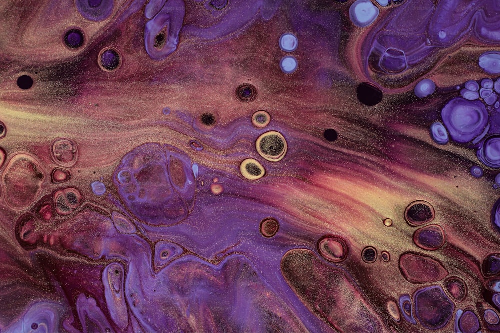Un primer plano de una pintura fluida púrpura y amarilla
