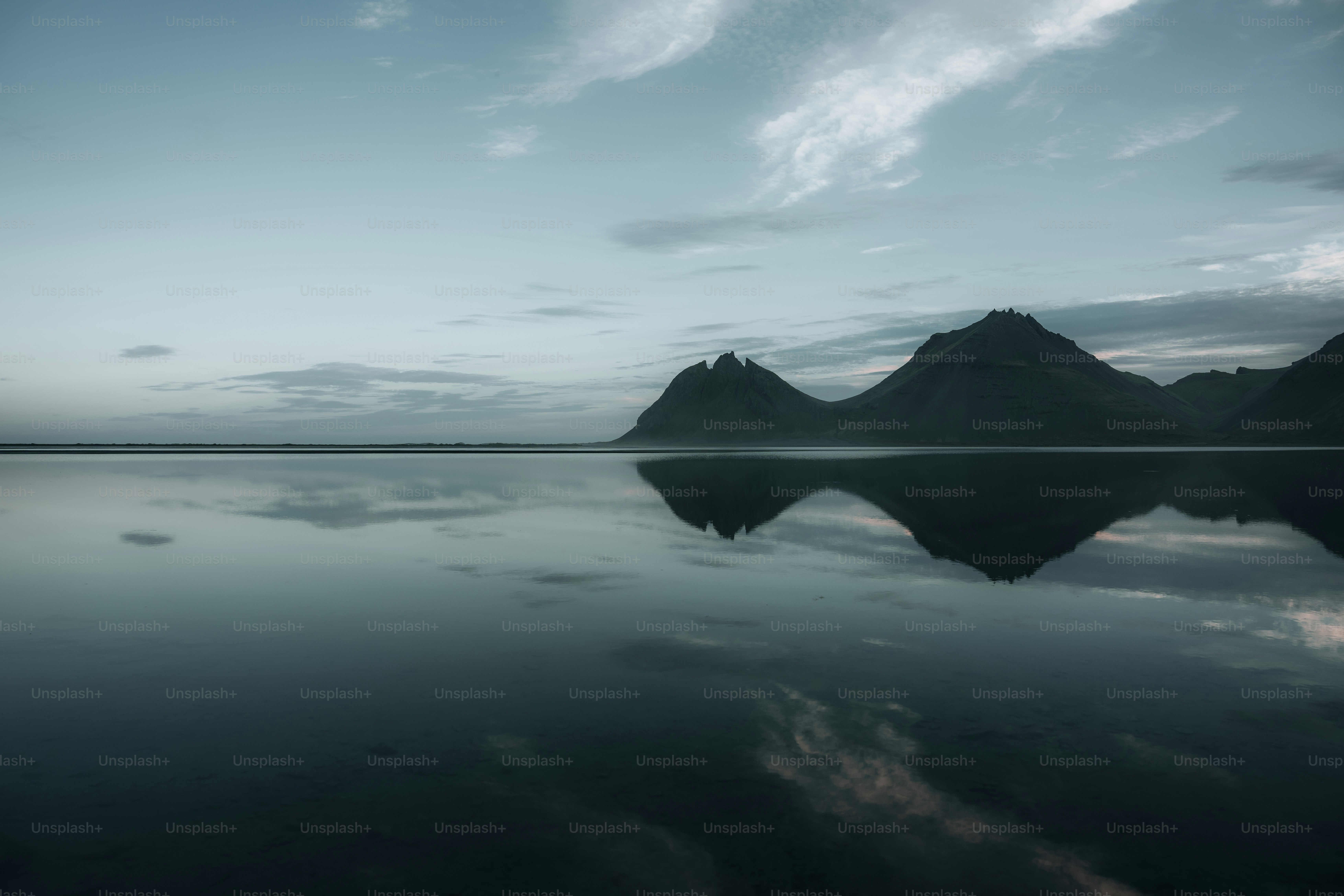 ein großes Gewässer mit Bergen im Hintergrund
