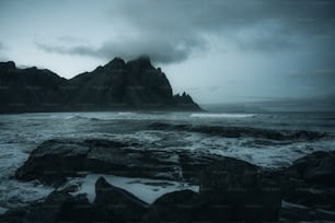 a large rock formation in the middle of a body of water