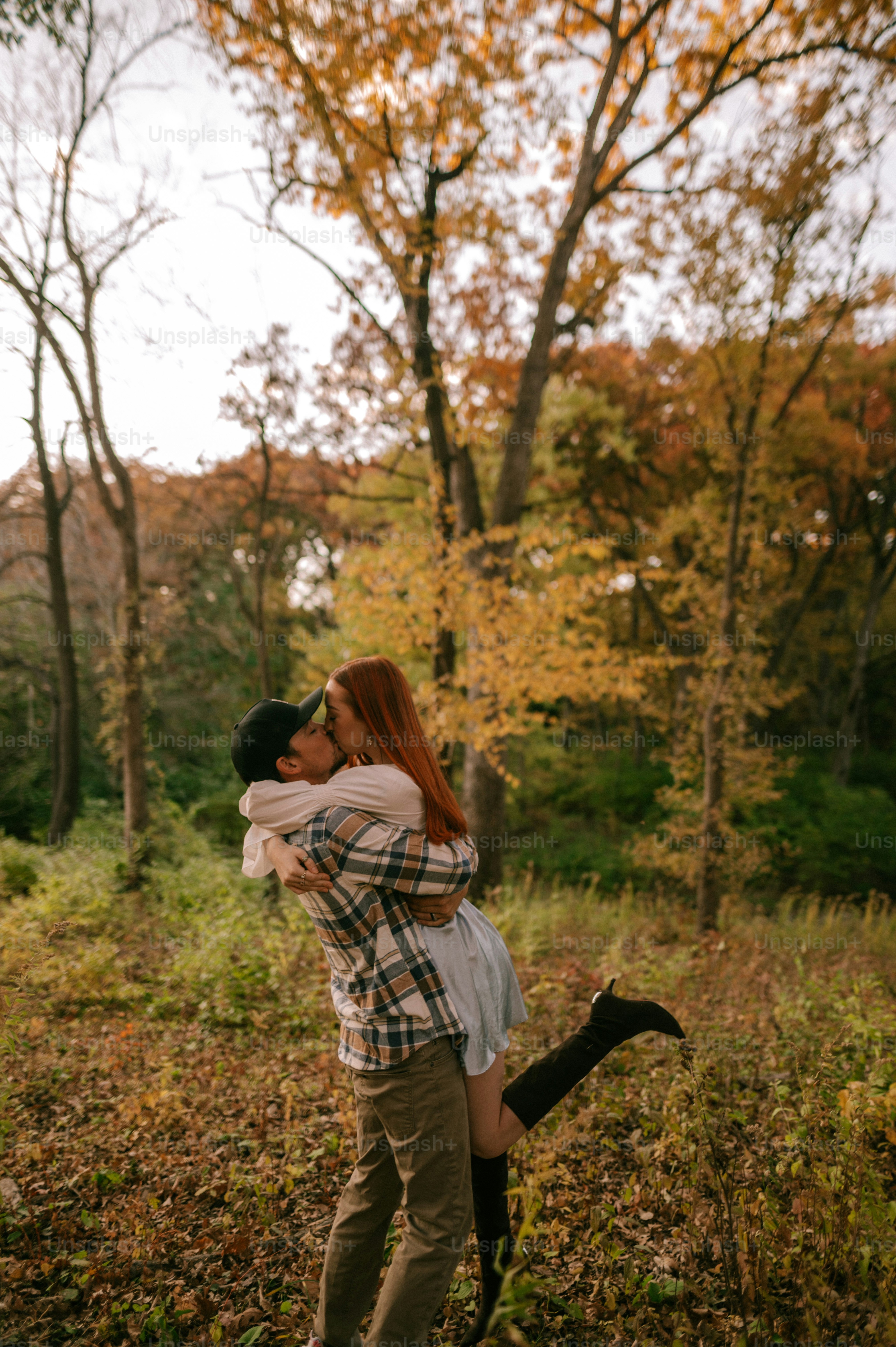 a man holding a woman in a forest