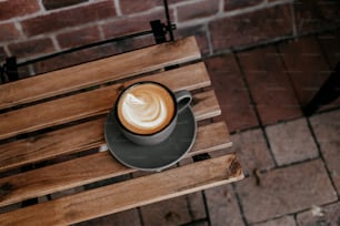 uma xícara de café sentada em cima de uma mesa de madeira