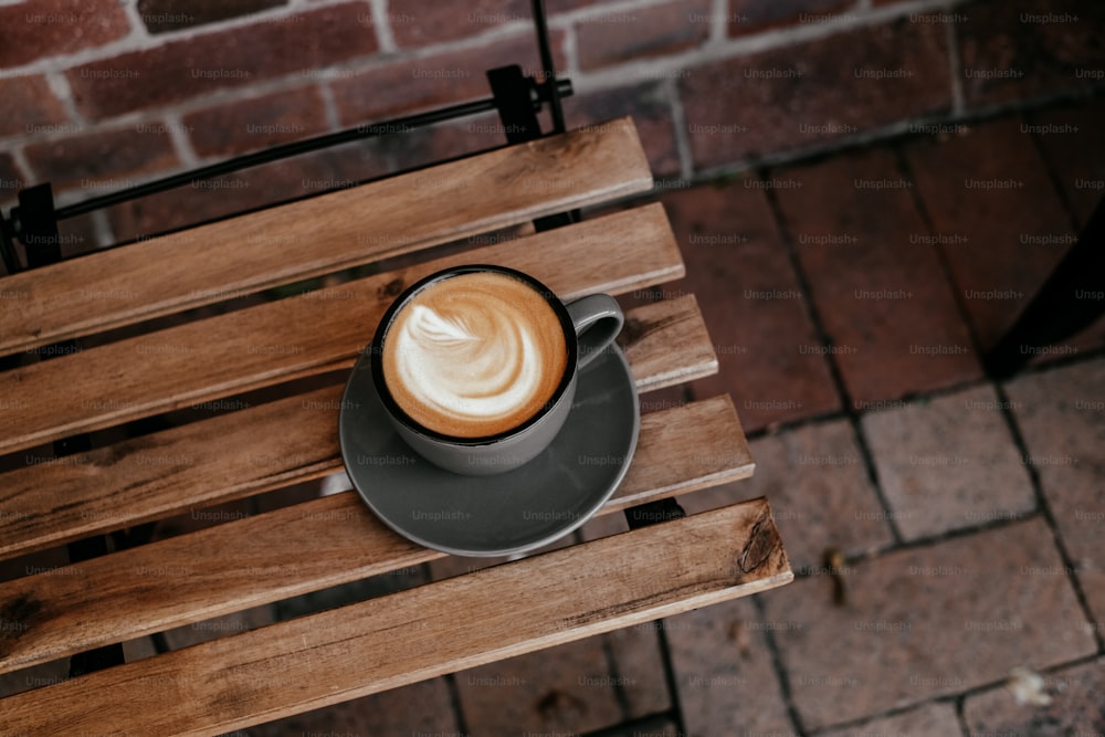 a cup of coffee sitting on top of a wooden table