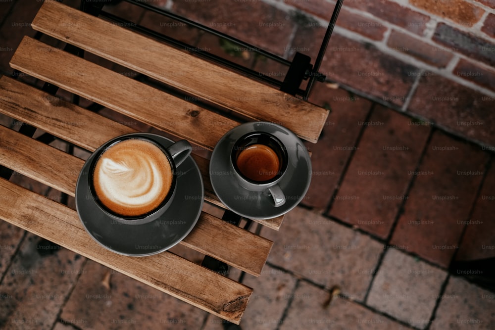 Dos tazas de café sobre una mesa de madera