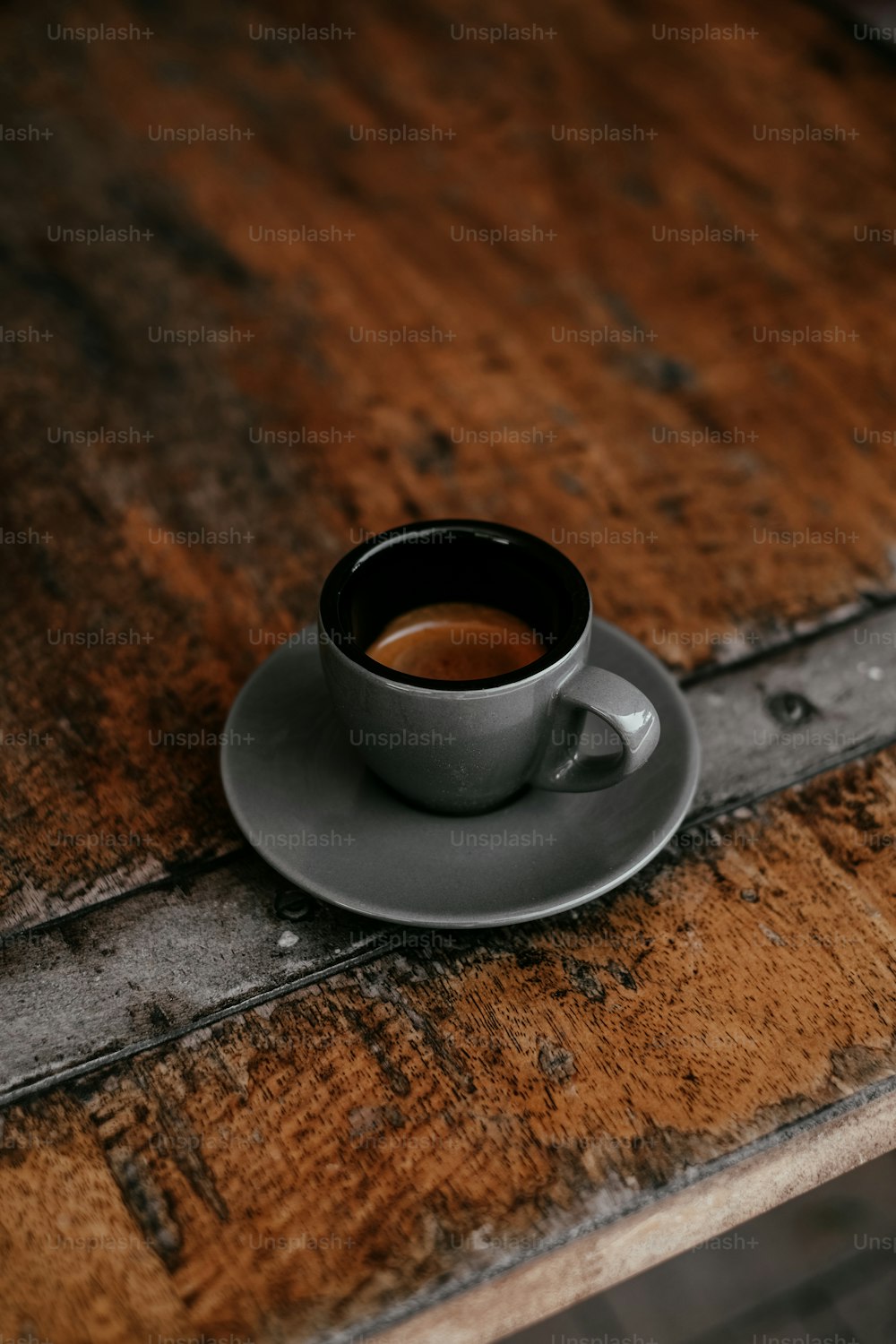 una taza de café encima de una mesa de madera