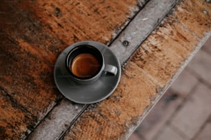 a cup of coffee sitting on top of a wooden table