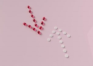 pilules débordant d’une bouteille sur une surface rose