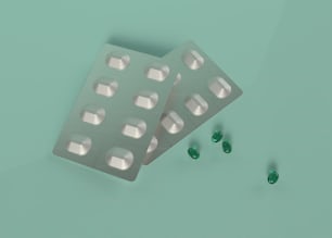 Dos píldoras y tres píldoras verdes sobre un fondo verde