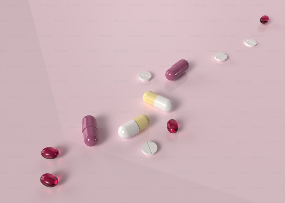 um grupo de pílulas sentado em cima de uma superfície rosa