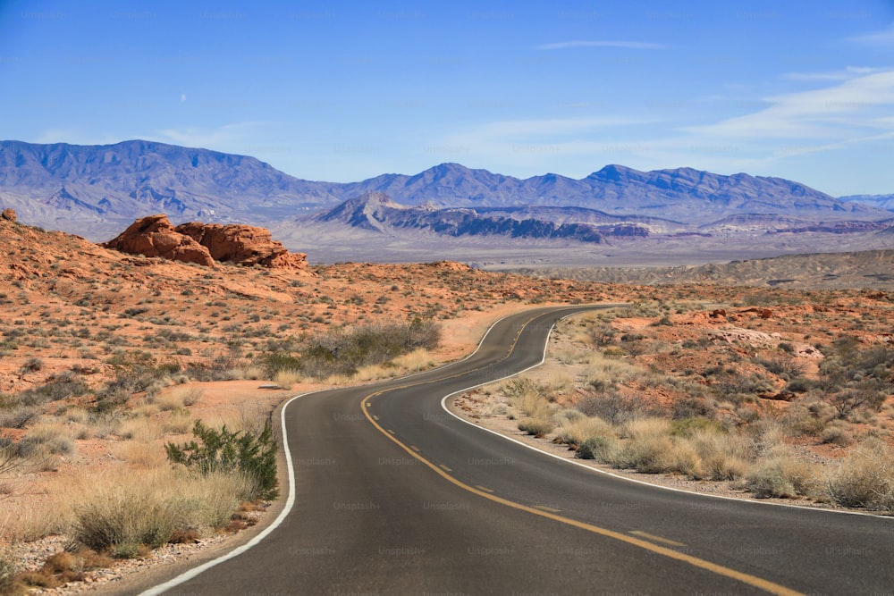 Eine Straße mitten in der Wüste mit Bergen im Hintergrund