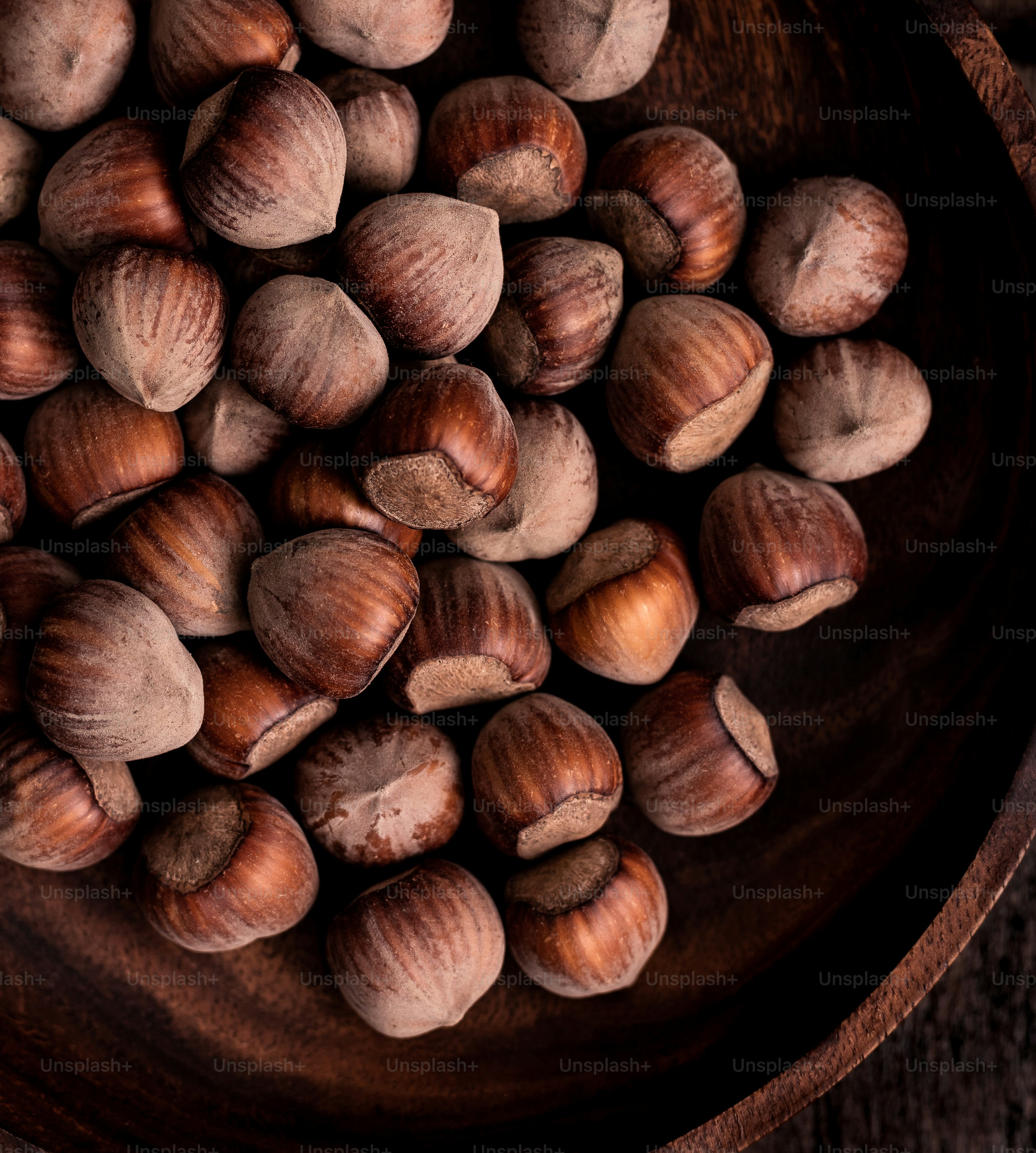 Un cuenco de madera lleno de nueces encima de una mesa