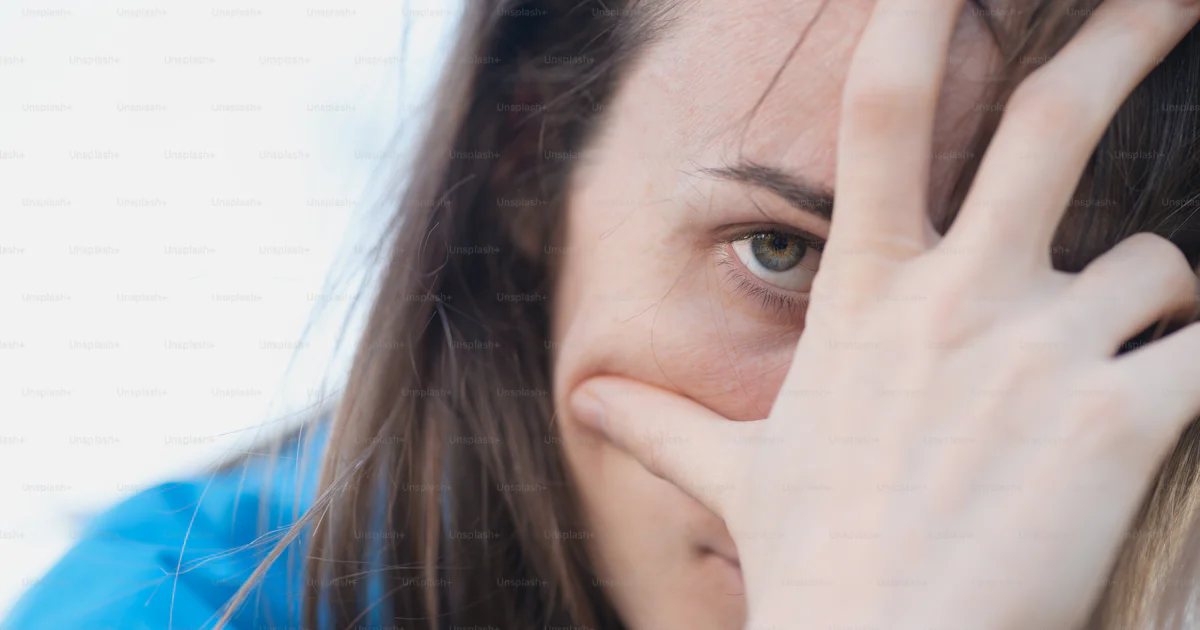 A close up of a person holding their hand to their face photo – Head ...