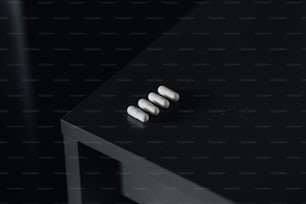 Tres píldoras sentadas encima de una mesa negra