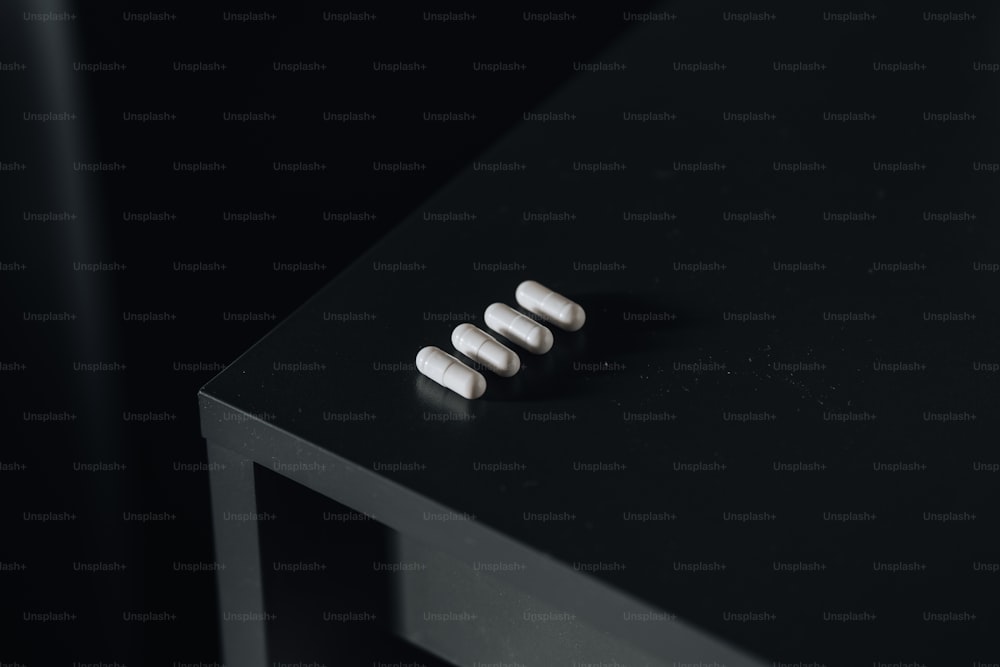 Trois pilules assises sur une table noire