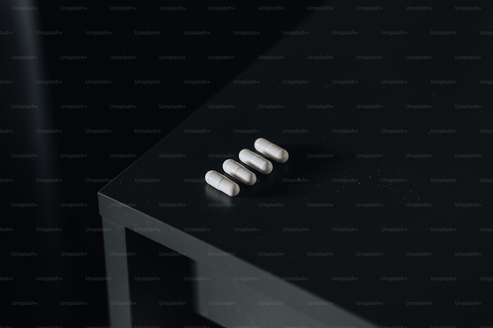 three pills sitting on top of a black table