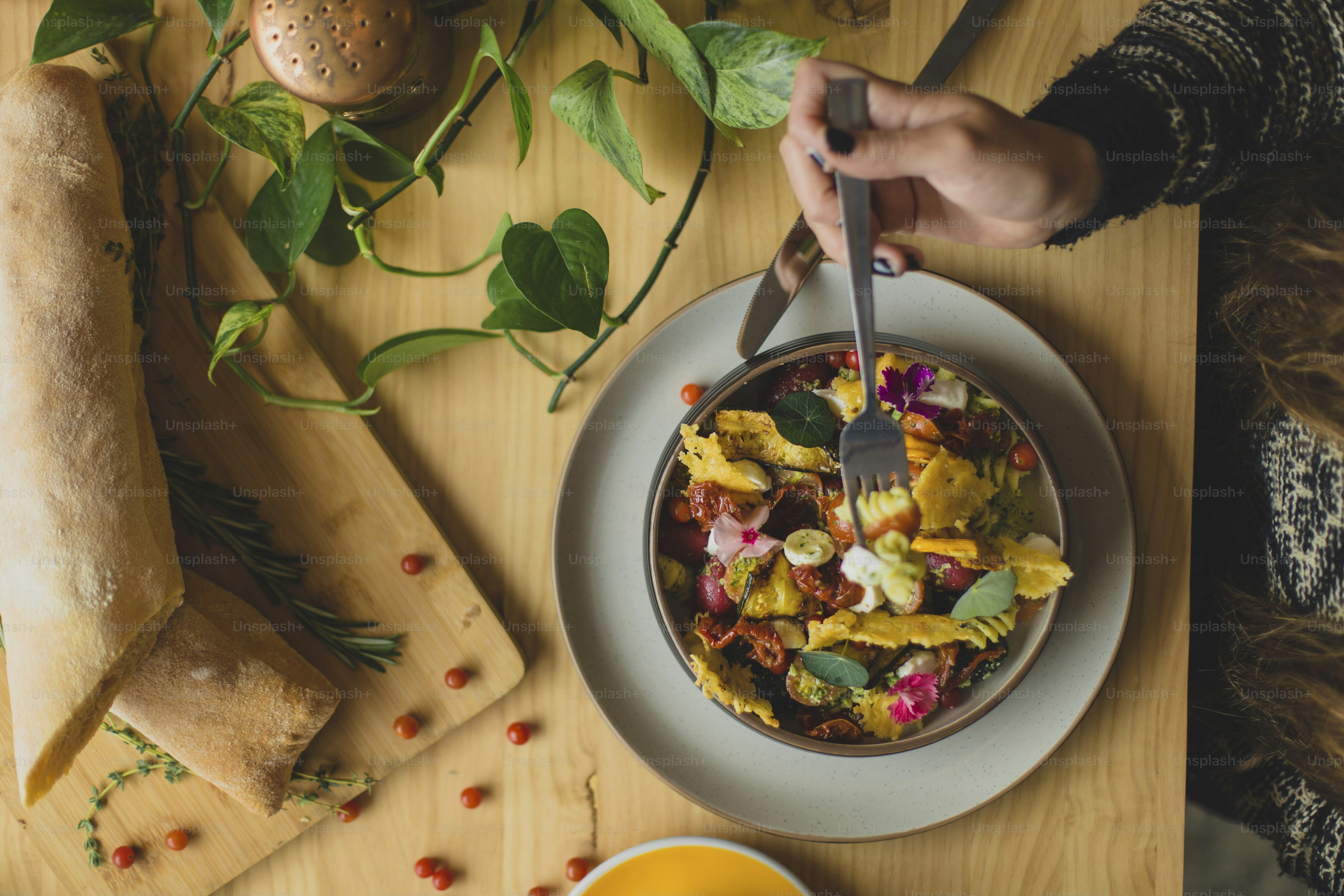 Una persona está comiendo un plato de comida en una mesa