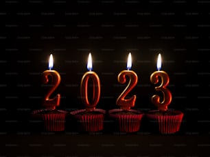 a row of red cupcakes with lit candles in the shape of numbers