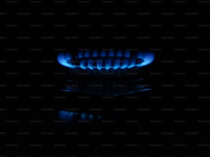 um fogão a gás com chamas azuis no escuro