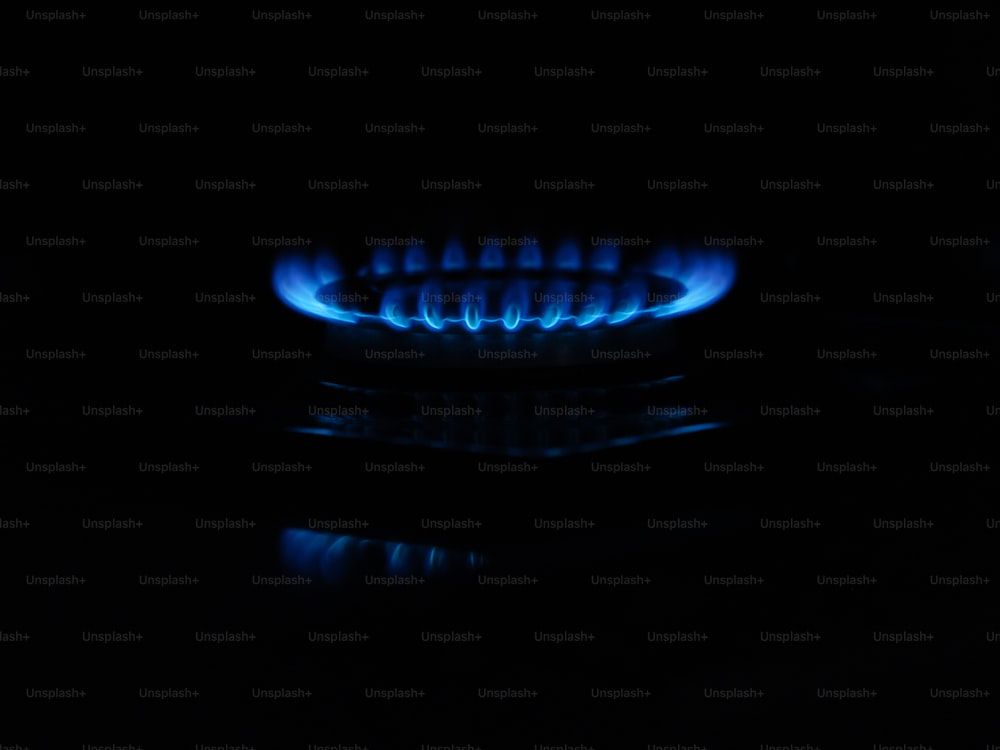 a gas stove with blue flames in the dark