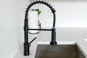 a kitchen sink with a black faucet over it