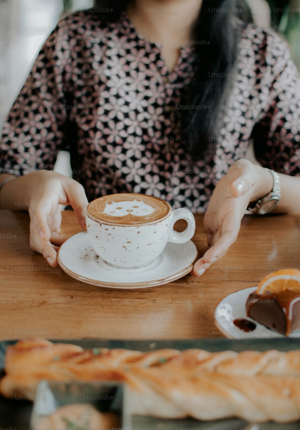 Eine Frau, die mit einer Tasse Kaffee an einem Tisch sitzt