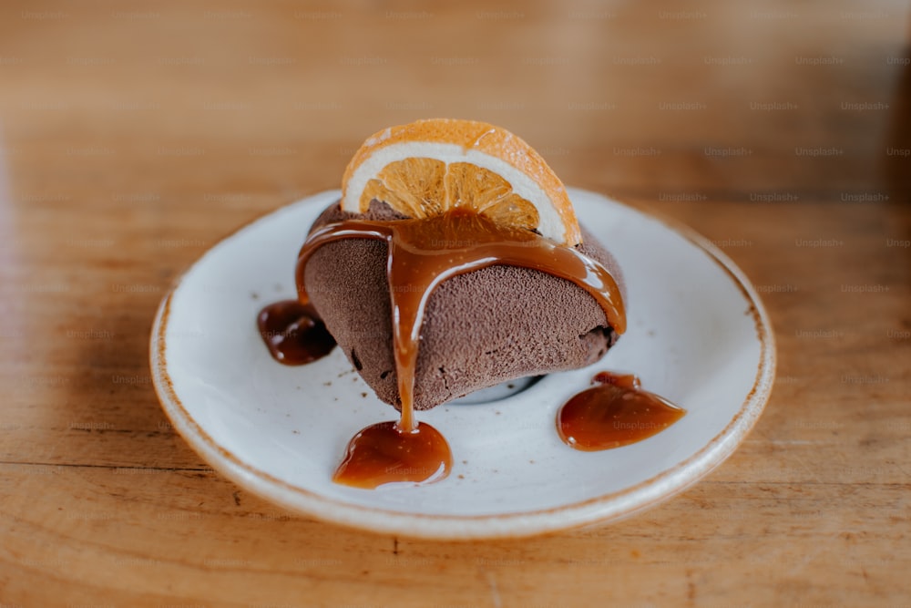 um pedaço de bolo de chocolate em um prato com um fio de caramelo