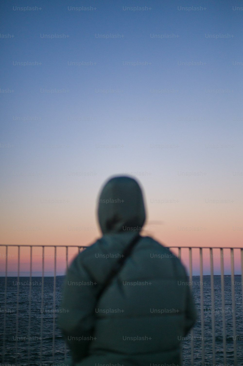 eine Person, die bei Sonnenuntergang auf den Ozean blickt