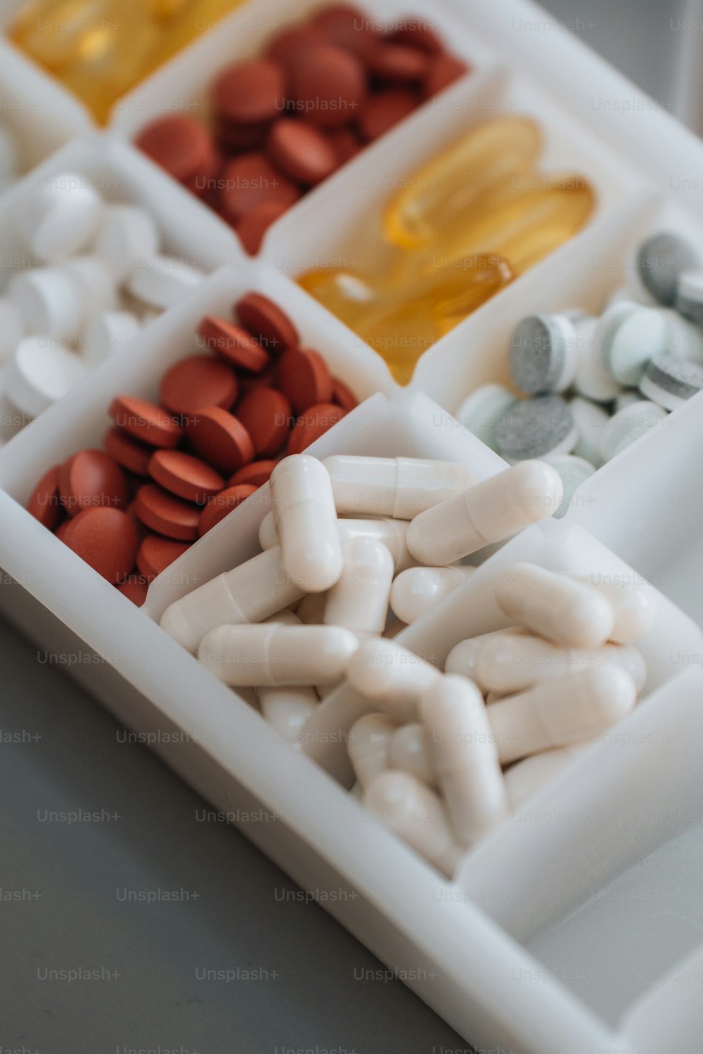 a white tray filled with pills and capsules