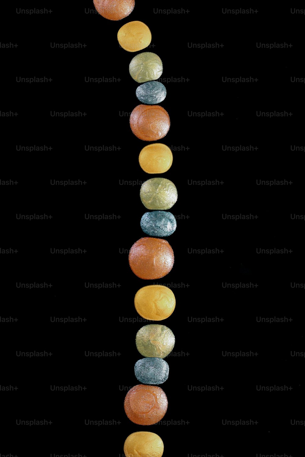 Una lunga fila di rocce di diversi colori su sfondo nero