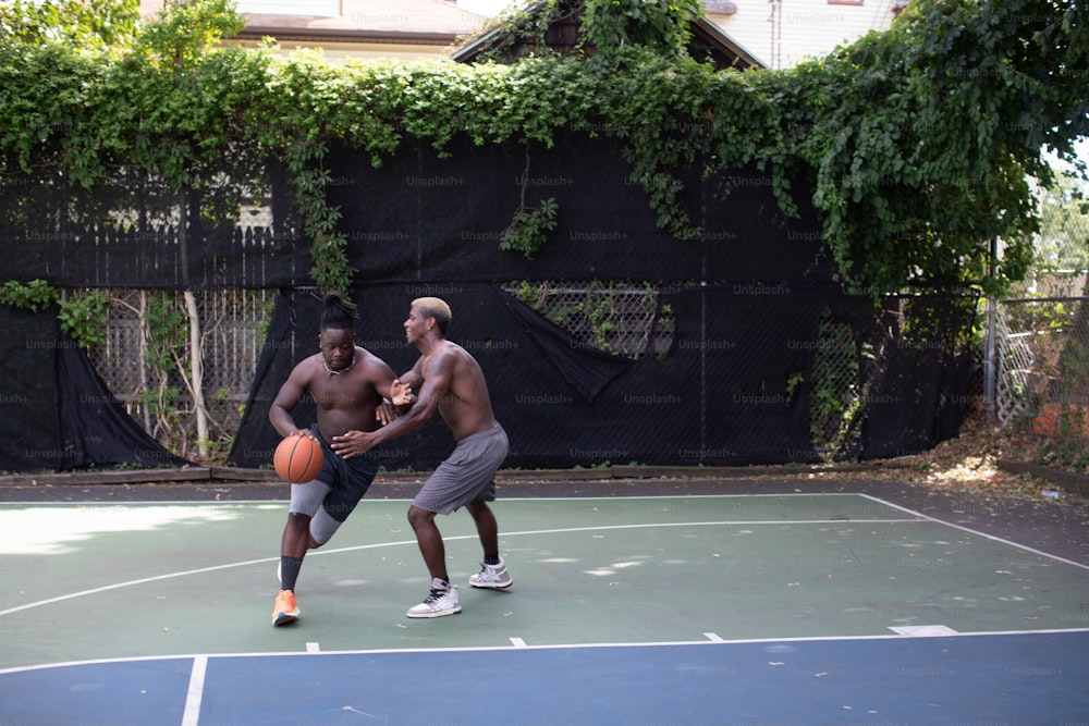 two men are playing basketball on a court
