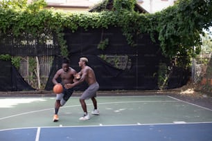 Dos hombres están jugando baloncesto en una cancha
