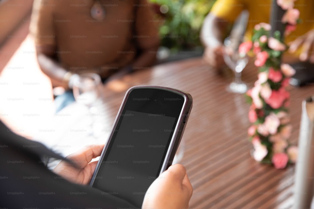 a person sitting at a table with a cell phone