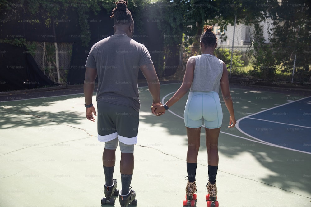 a man and a woman holding hands on a tennis court