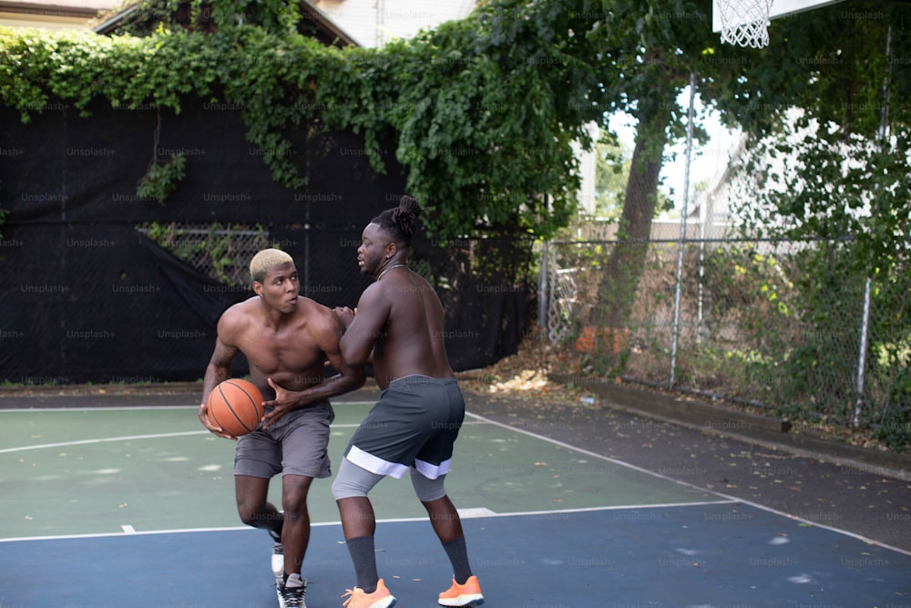 a couple of men standing on top of a basketball court