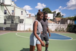 a couple of people standing on a basketball court