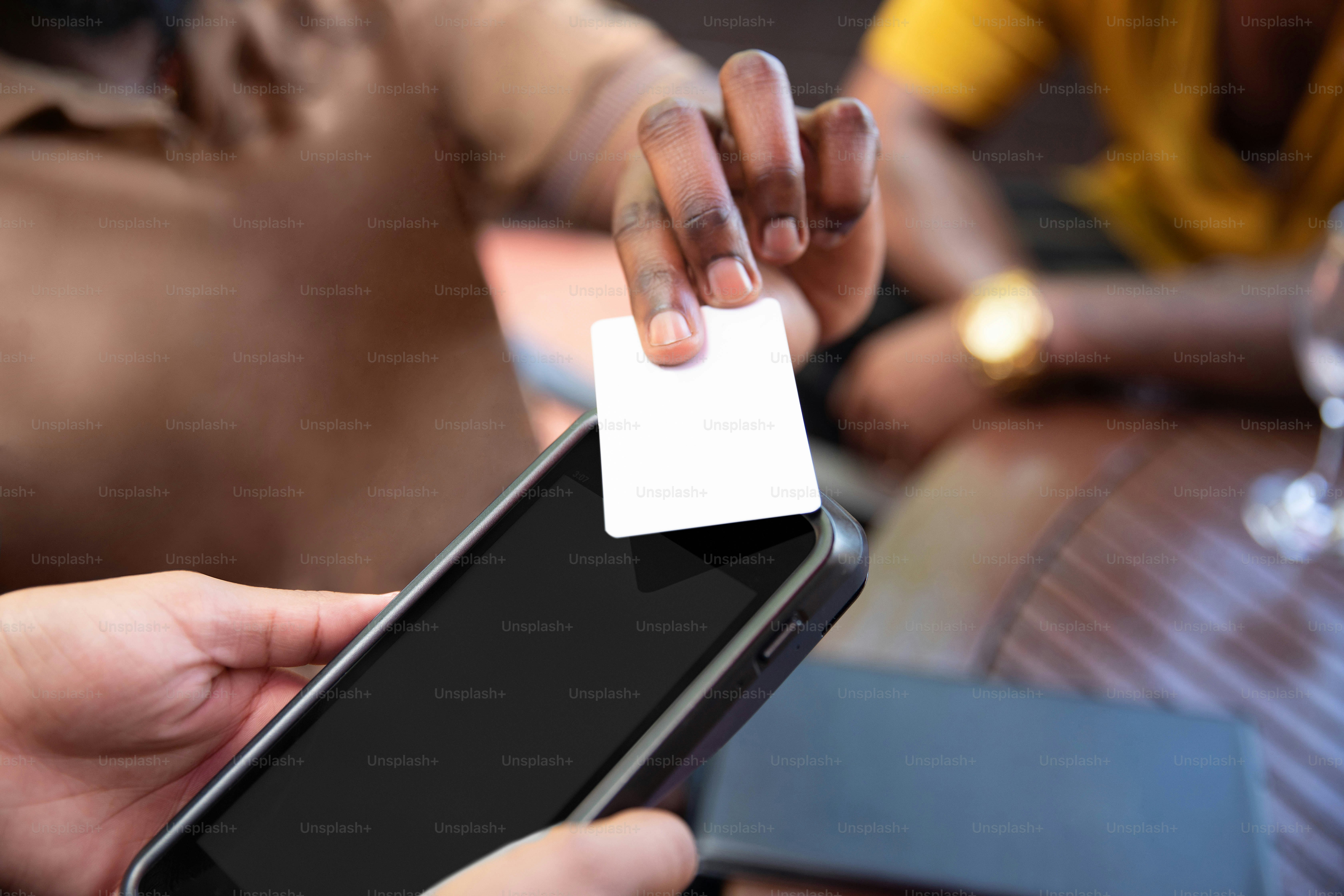 a person holding a cell phone with a white card in their hand