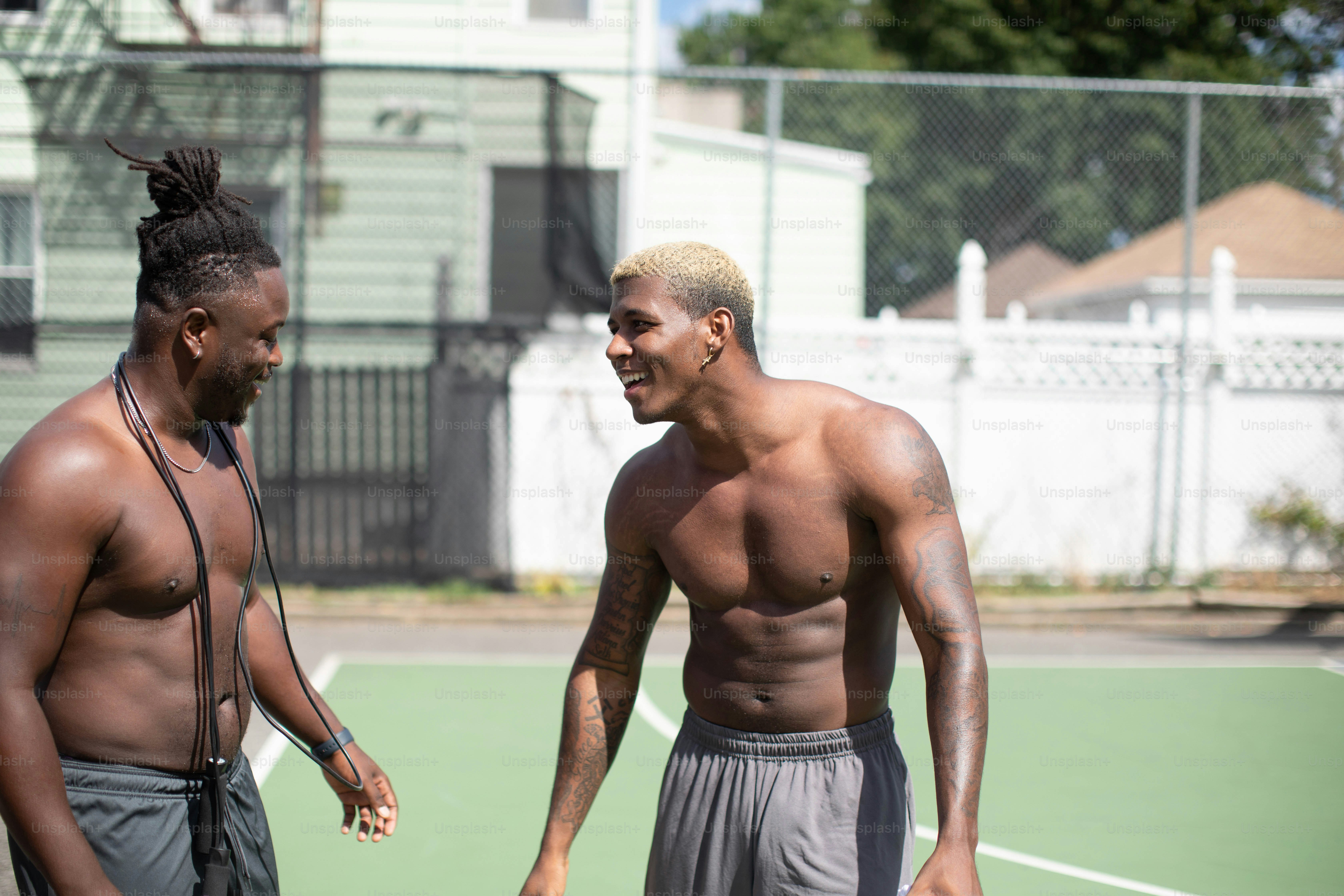 a couple of men standing on top of a tennis court