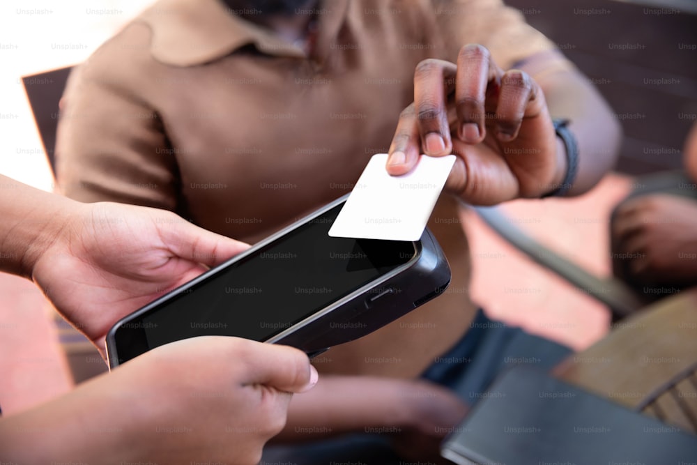 a person holding a smart phone with a business card in their hand